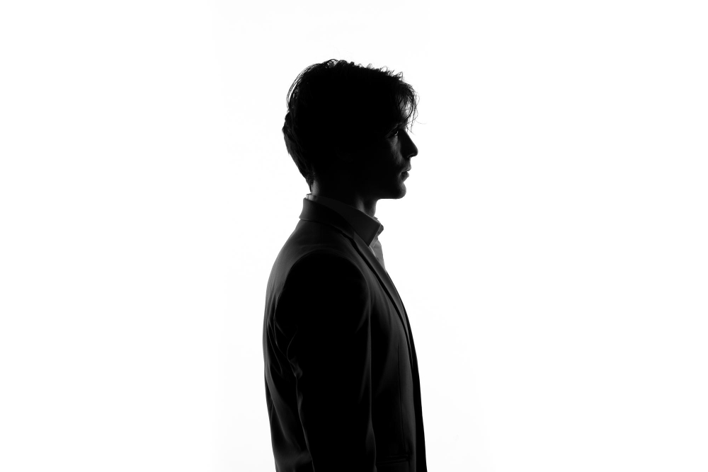 silueta-persona-masculina-traje-estricto-vista-lateral-sombra-retroiluminada-fondo-blanco